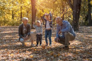 grandchildren grandparents throwing leaves park spending time together grandchildren grandparents throwing leaves park spending time together