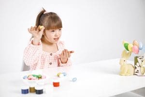 portrait charming girl with down syndrome playing with easter colored eggs portrait charming girl with down syndrome playing with easter colored eggs